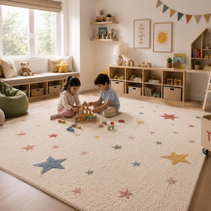 May include: A large, rectangular, cream-colored area rug featuring a scattered pattern of embroidered stars in various muted tones, including blue, yellow, pink, and green. The rug has a soft, textured pile and covers a significant portion of the floor.
