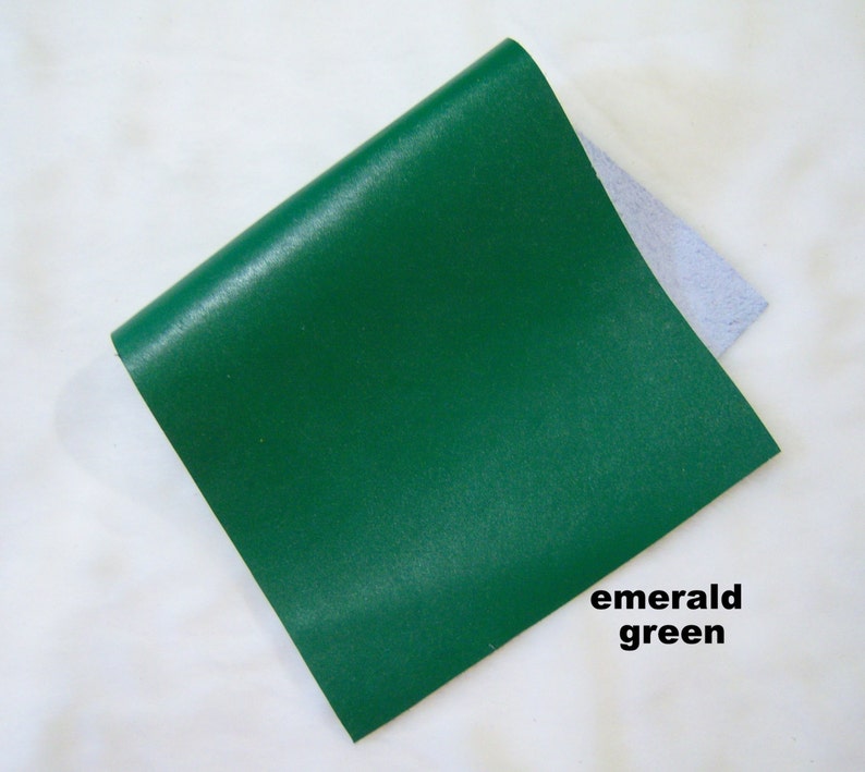 May include: A square piece of emerald green leather. The leather is smooth and has a slight sheen.