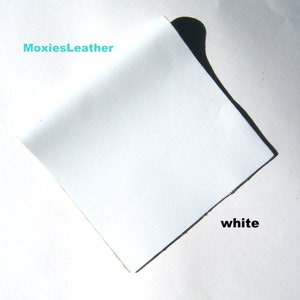 May include: A white piece of leather with the text "MoxiesLeather" and "white" written on it.