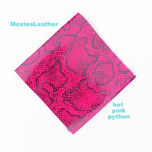 May include: A square piece of hot pink python leather with a black snake skin pattern. MoxiesLeather.