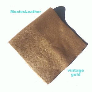 May include: A piece of vintage gold leather. The leather has a textured surface and is a rich, warm gold color.