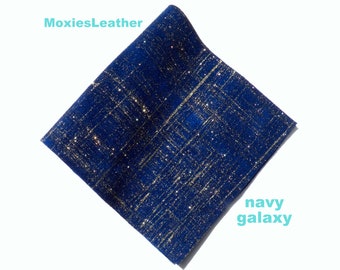 Może przedstawiać: Zbliżenie na ciemnoniebieski materiał z wplecionymi złotymi cekinami. Materiał ma fakturowaną, tkany wygląd. Tekst "navy galaxy" jest napisany na biało w prawym dolnym rogu obrazu.