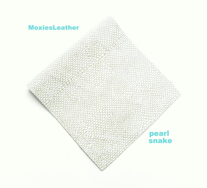 May include: A white leather sheet with a textured snake skin pattern. The text "MoxiesLeather" is in the top left corner and "pearl snake" is in the bottom right corner.