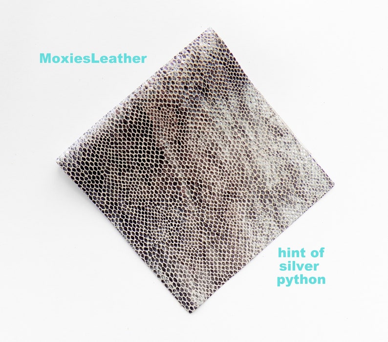 May include: A piece of silver python leather with a hint of grey. The leather has a textured, scaly pattern.