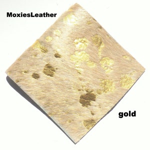 May include: A piece of beige cowhide leather with gold metallic spots.  The leather is soft and supple, and the gold spots are evenly distributed.  MoxiesLeather gold.