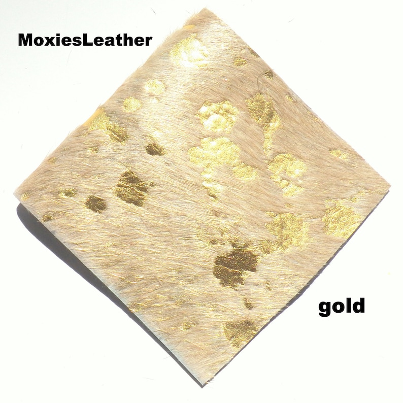 May include: A piece of beige cowhide leather with gold metallic spots.  The leather is soft and supple, and the gold spots are evenly distributed.  MoxiesLeather gold.