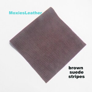Può includere: Un pezzo quadrato di tessuto in pelle scamosciata marrone con strisce verticali. Il tessuto è strutturato e ha una sensazione morbida e vellutata.