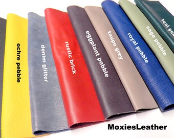 May include: A variety of leather swatches in different colors and textures, including black pebble, ochre pebble, denim glitter, rustic brick, eggplant pebble, taupe grey, royal pebble, sage pebble, and teal pebble. The swatches are arranged in a row, with the text "MoxiesLeather" visible at the bottom of the image.
