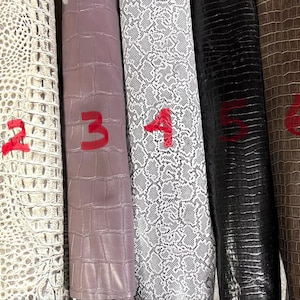 May include: Seven vertical strips of textured material labelled 1 through 7. The textures include black crocodile, white crocodile, solid mauve, white and black snakeskin, black crocodile, brown crocodile, and beige crocodile patterns.