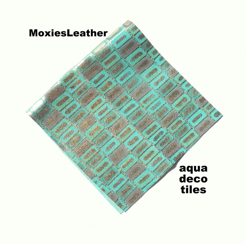 Puede incluir: Cuero sint&eacute;tico azul aguamarina con un patr&oacute;n geom&eacute;trico de purpurina dorada. El patr&oacute;n se asemeja a azulejos decorativos. El texto "MoxiesLeather" est&aacute; en la esquina superior izquierda de la imagen.