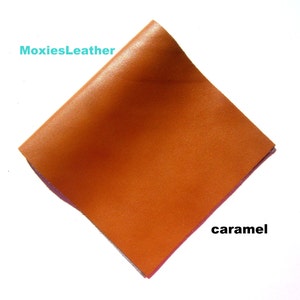 May include: A square piece of caramel coloured leather. The leather is smooth and has a slight sheen. The text "MoxiesLeather" is in the top left corner of the image. The text "caramel" is in the bottom right corner of the image.