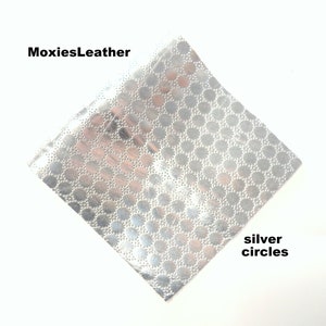 Puede incluir: Primer plano de una hoja de cuero plateado con un patr&oacute;n repetitivo de peque&ntilde;os c&iacute;rculos. El texto "MoxiesLeather" est&aacute; en la esquina superior izquierda de la imagen. El texto "silver circles" est&aacute; en la esquina inferior derecha de la imagen.