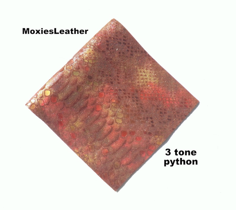 Puede incluir: Primer plano de un trozo de cuero de pit&oacute;n rojo, dorado y marr&oacute;n con un patr&oacute;n de piel de serpiente. El texto "3 tone python" est&aacute; escrito debajo del cuero.