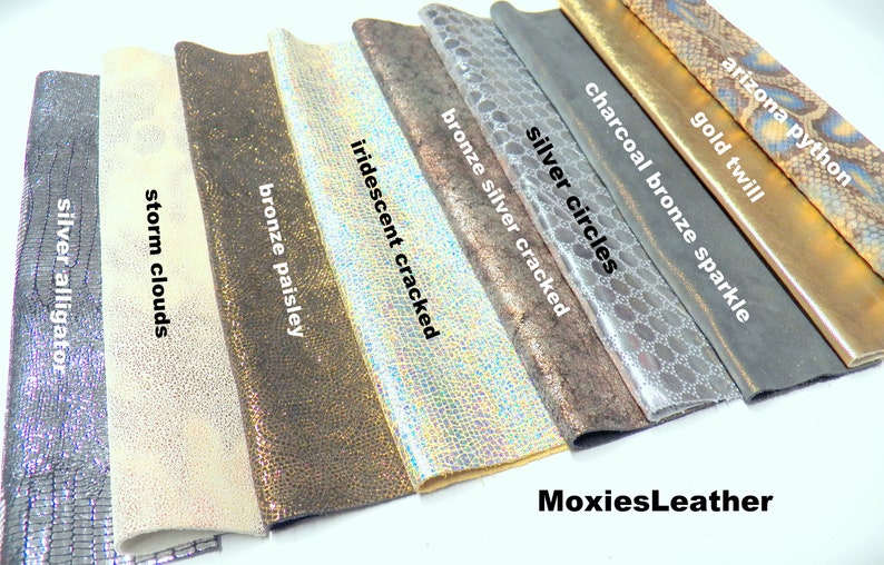Puede incluir: Primer plano de diez muestras de cuero diferentes, cada una con una textura y un color &uacute;nicos. Las muestras est&aacute;n etiquetadas con nombres como "cocodrilo plateado", "nubes de tormenta", "cachemira bronce", "craquelado iridiscente", "craquelado plateado bronce", "c&iacute;rculos plateados", "chispas bronce carb&oacute;n", "sarga dorada" y "pit&oacute;n de Arizona". El texto "MoxiesLeather" es visible en la parte inferior de la imagen.