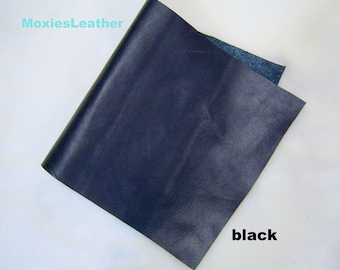 May include: A piece of black leather with a textured surface. The word "black" is written in white in the lower right corner. The brand name "moxiesLeather" is in the upper left corner.