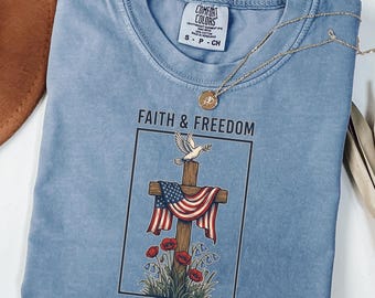 Camiseta "Fé e Liberdade" em Cores Confortáveis | Camiseta Vintage com Cruz e Bandeira Americana de 1776 | Camiseta Comemorativa do 250º Aniversário dos EUA - Presente Cristão para o 4 de Julho de 2026