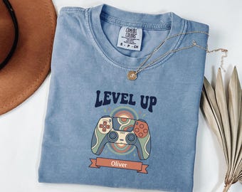 Camiseta personalizada Comfort Colors Level Up Gamer para aniversário, com nome personalizado, estilo retrô boho, com controle de videogame, ideal para presentear meninos e meninas em festas infantis.