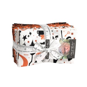 May include: A stack of fabric squares with a white background and black and orange designs. The fabric is tied with a white ribbon and a tag that says "moda fabrics & supplies".