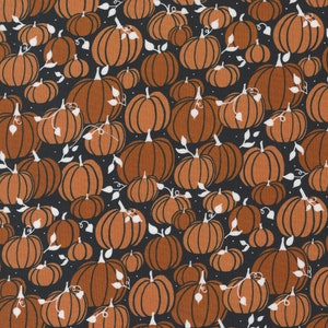 May include: A repeating pattern of orange pumpkins with dark brown outlines and green stems on a dark gray background. White leaf and vine accents are scattered throughout the design, creating a fall or harvest theme.