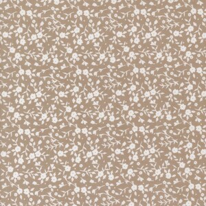 May include: A fabric with a repeating pattern of small white flowers and leaves on a tan background. The floral design is evenly distributed across the surface, creating a delicate and detailed texture. This fabric is suitable for various sewing projects.