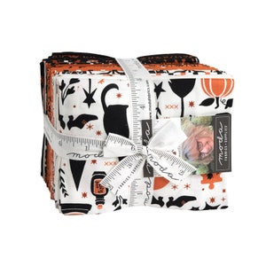 May include: A stack of Halloween-themed fabric squares tied with a white ribbon. The fabric features black and orange patterns with Halloween motifs like cats, stars, and pumpkins. The ribbon has a ruler design and the word "moda".