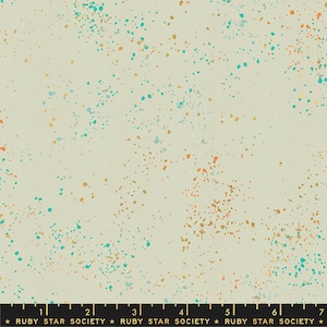 May include: A beige fabric with a speckled pattern of teal, gold, and orange dots. The fabric is marked with a ruler and the text "RUBY STAR SOCIETY".