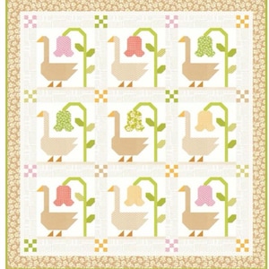 May include: A patchwork quilt featuring a repeating pattern of geese and flowers. The geese are tan with yellow beaks, and the flowers are pink, yellow, and green. The quilt has a floral border and measures 61 3/4 inches by 65 1/2 inches.