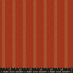 May include: Red fabric with thin, gold stripes. The fabric has a textured, woven appearance. The fabric is marked with a ruler and the text "RUBY STAR SOCIETY".