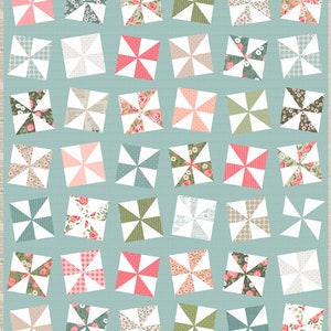 May include: A patchwork quilt with a pinwheel design. The quilt features numerous pinwheel blocks in various colors and patterns, including floral prints, solid colors, and geometric designs. The background is a light blue color.