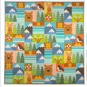 May include: A colorful patchwork quilt featuring a woodland scene. The design includes squares with images of bears, rabbits, birds, mountains, trees, mushrooms, and suns. The quilt is primarily blue, green, orange, and yellow.