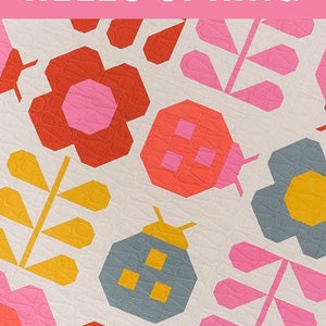 May include: A quilt pattern cover with the text "HELLO SPRING" in white on a pink banner. The design features colorful geometric flowers, leaves, and ladybugs in red, pink, yellow, and blue. The text at the bottom reads "A traditionally pieced quilt pattern for the advanced beginner sewist and up."