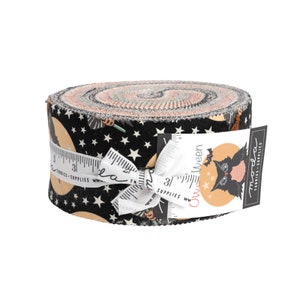 May include: A black and white fabric roll with a repeating pattern of stars, moons, and witches flying on broomsticks. The fabric roll is tied with a white ribbon and has a label that says "Owloween" and features a black cat with a moon behind it. The label also says "Moda Fabrics - Supplies".