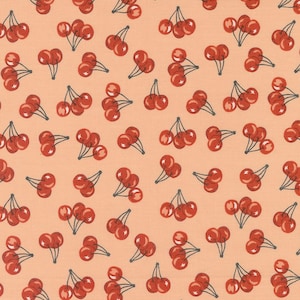 May include: A peach-colored fabric with a repeating pattern of red cherries. The cherries are clustered together in groups of three and have a white highlight on each cherry.