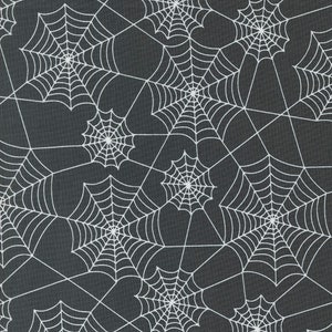 May include: A dark gray fabric with a repeating pattern of white spiderwebs. The webs are intricately designed, with radial lines emanating from a central point. The design is suitable for Halloween or gothic-themed crafts.