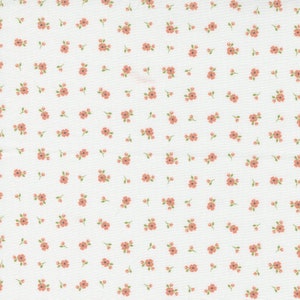 May include: White fabric with a repeating pattern of small pink flowers.