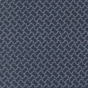 May include: A navy blue fabric with a repeating pattern of white interlocking circles. The design creates a textured, geometric effect, suitable for various textile applications.