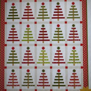 May include: A white fabric quilt with a red border and a pattern of green and red Christmas trees. The quilt is precut and friendly.