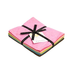 May include: A stack of 12 fat quarter fabric squares in a rainbow of colors with a pink speckled fabric on top. The fabric is tied with a black ribbon and a tag that says "For your creative bundles".