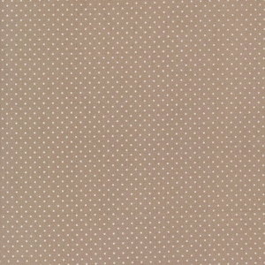 May include: A close-up of a tan fabric with a repeating pattern of small, evenly spaced white polka dots. The fabric has a textured appearance, suggesting it may be cotton or a similar material. The polka dots are consistent in size and shape.