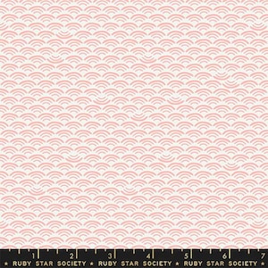 May include: A white fabric with a repeating pattern of pink overlapping semi-circles. The fabric has a ruler with the text "RUBY STAR SOCIETY" printed on it.