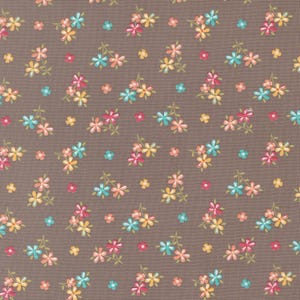 May include: A fabric with a repeating floral pattern. The flowers are in shades of pink, yellow, and teal, set against a brown background. The design features small, clustered blossoms and scattered single flowers.