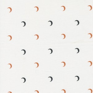 May include: A white fabric with a repeating pattern of brown and black crescent moons.