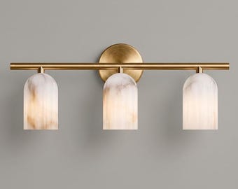 Pode incluir: Um candeeiro de parede de três luzes com uma barra horizontal em latão escovado e um suporte circular. Três abajures em forma de cúpula feitos de vidro marmoreado branco e bege estão suspensos na barra, proporcionando uma luz suave.