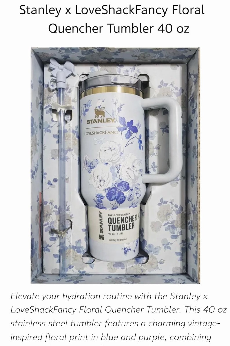 May include: A white 40 oz Stanley x LoveShackFancy Quencher tumbler with a blue and purple floral pattern, a side handle, a clear lid, and a matching straw with a bow topper, all packaged in a floral-patterned box with the product name printed.
