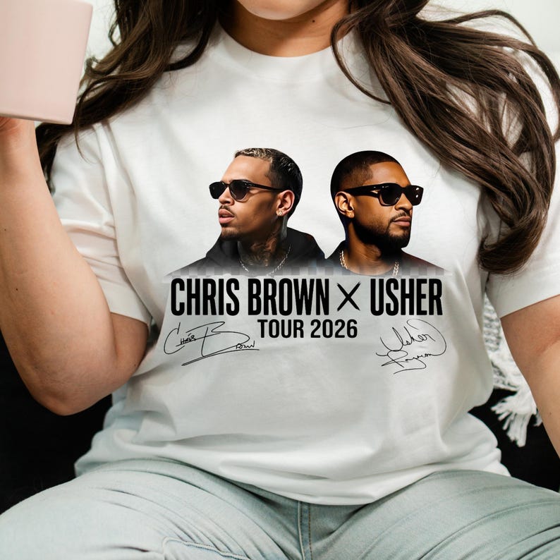 May include: White t-shirt featuring a graphic of Chris Brown and Usher wearing sunglasses. The text "CHRIS BROWN X USHER TOUR 2026" is printed below the image, along with their signatures.