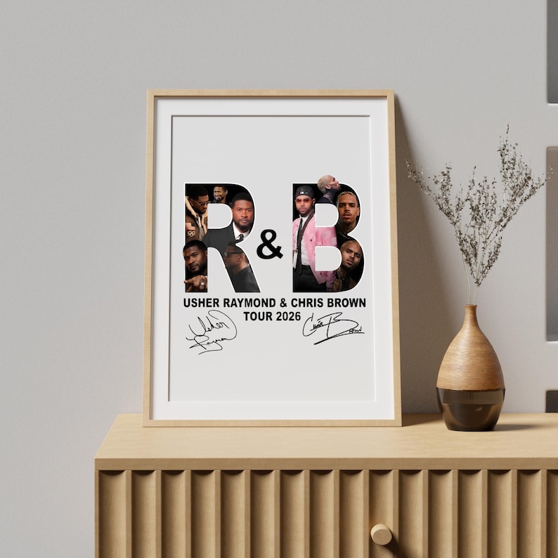 May include: Framed poster featuring the letters "R&B" with images of Usher Raymond and Chris Brown. The poster includes the text "USHER RAYMOND & CHRIS BROWN TOUR 2026" and signatures. The frame is a light wood color.