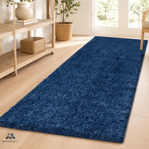 May include: A rectangular runner rug featuring a deep navy blue colour and a thick, shaggy pile texture. The rug is positioned lengthwise on a light-coloured wooden floor, extending from the foreground towards the back of the room.