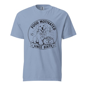 Może przedstawiać: Jasnoniebieski t-shirt z czarną grafiką psa noszącego bandanę z napisem BORN TO EAT TRAINED TO BEG. Wzór zawiera miskę z napisem MY BOWL MY RULES oraz tekst FOOD MOTIVATED SINCE BIRTH i FOOD IS MY LOVE LANGUAGE.