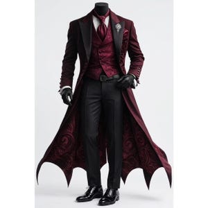 May include: A formal burgundy suit with a long coat, black pants, and a vest. The coat has a black lapel and a unique, patterned lining. The outfit includes a tie, a brooch, and black gloves. The suit is displayed on a mannequin.