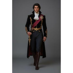 May include: A black velvet coat with gold embroidery, a burgundy sash, and a gold belt. The outfit includes dark grey trousers, brown boots, and a white ruffled shirt. A gold dagger is held in the right hand.